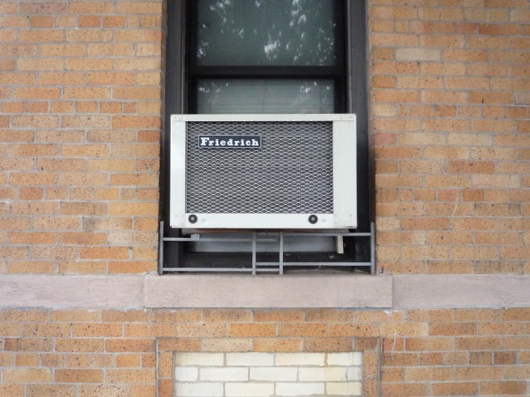 Window air conditioning unit on a red brick building