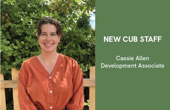 A photo of Cassie, wearing an orange shirt sitting in front of greenery. Beside the photo is a description