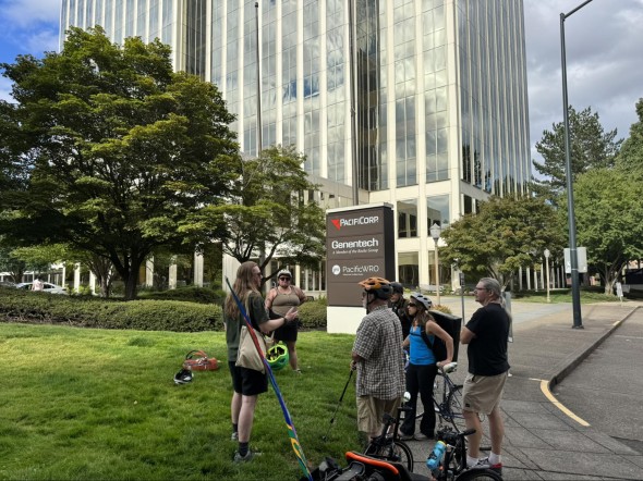 A group of community members gathers at the end of the NE grid bike tour to discuss Pacific Power's rate request and learn how to take action at the 7/26 PUC hearing.
