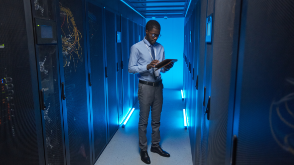 Man holding computer in data center
