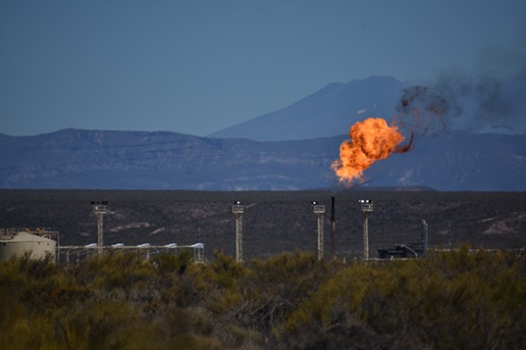 Gas flare in front of mountains