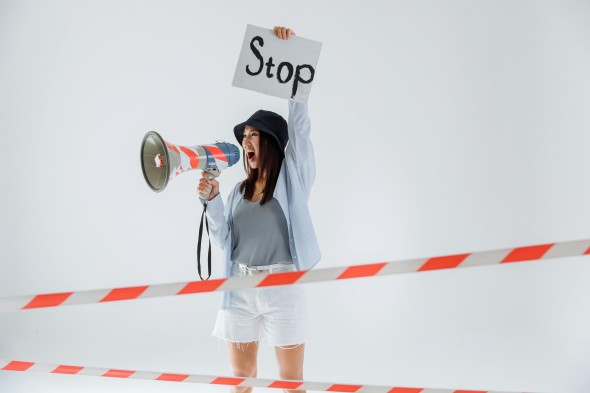 Girl with megaphone holding a sign that says