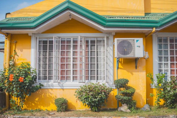Heat pump on a bright yellow house
