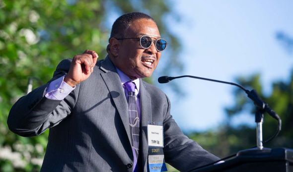 Mark Toney speaking on a blue background
