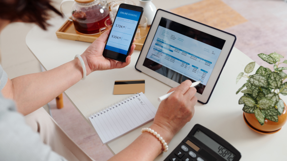 Woman paying her energy bill on computer and phone