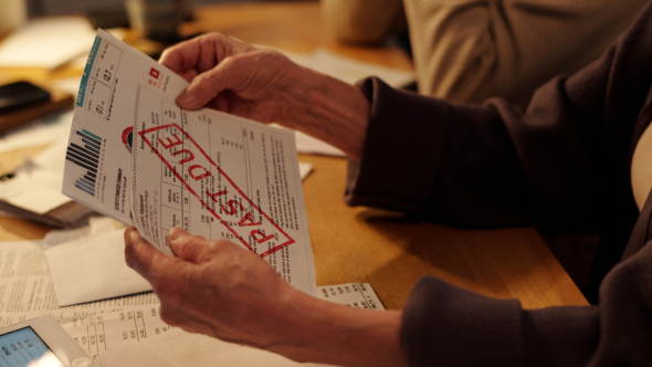 Senior holding past due energy bill notice