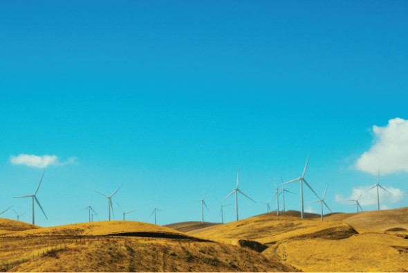 Wind turbines on hills with blue sky