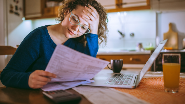 Woman holding her head looking at an energy bill