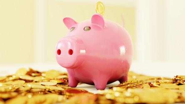 Pink piggy bank sits on a pile of gold coins