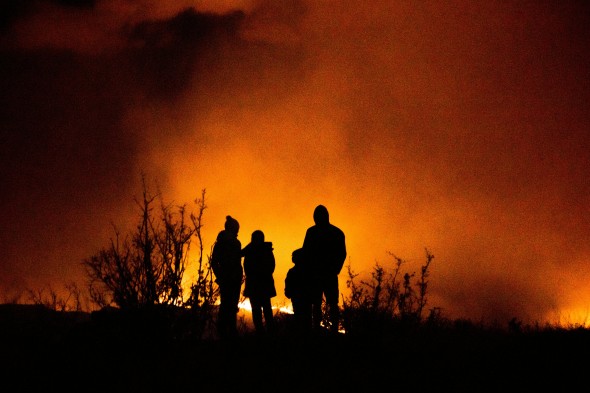 Family watching fire outline in black on orange background