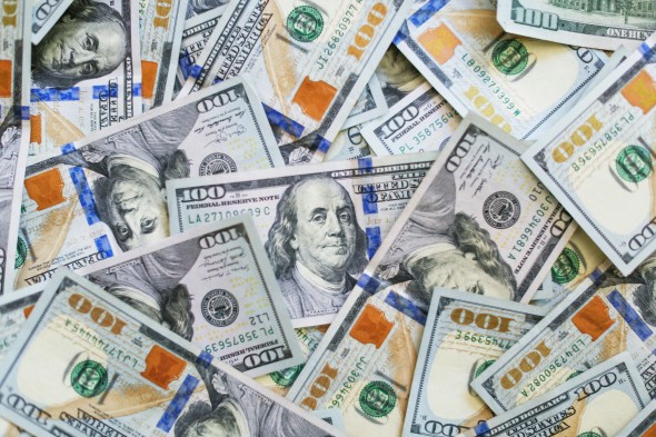 One hundred dollars bills in a pile
