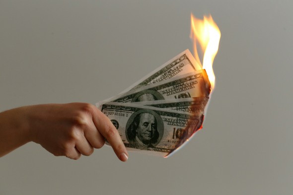 Hand holding burning money