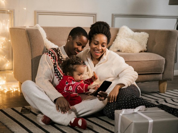 Queer couple with baby sitting on beige living room floor
