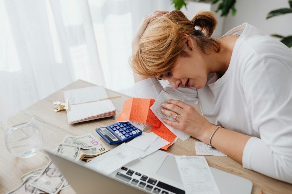 Women leaning over bills stressed out
