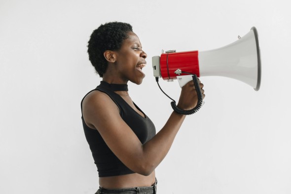 Woman stands speaking into a megaphone