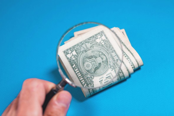 Magnifying glass over dollar bills