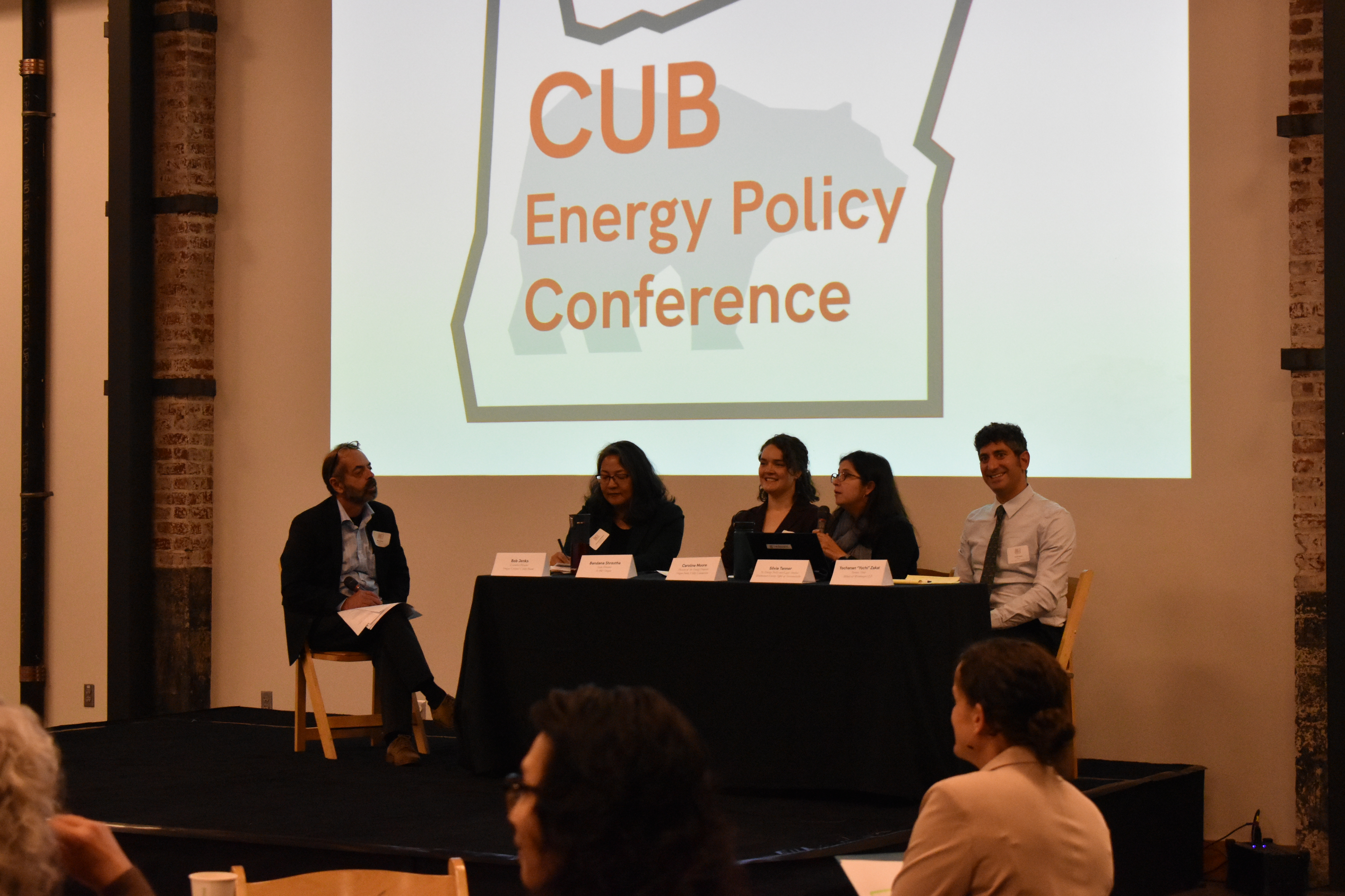 Five people sit on stage for a panel